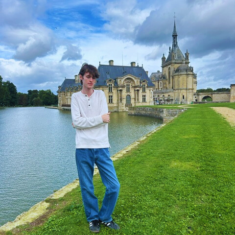 student standing in front of Chateau in Chantilly