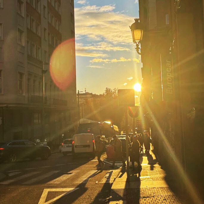 student took a picture of the sunset peeking through some buildings in Madrid