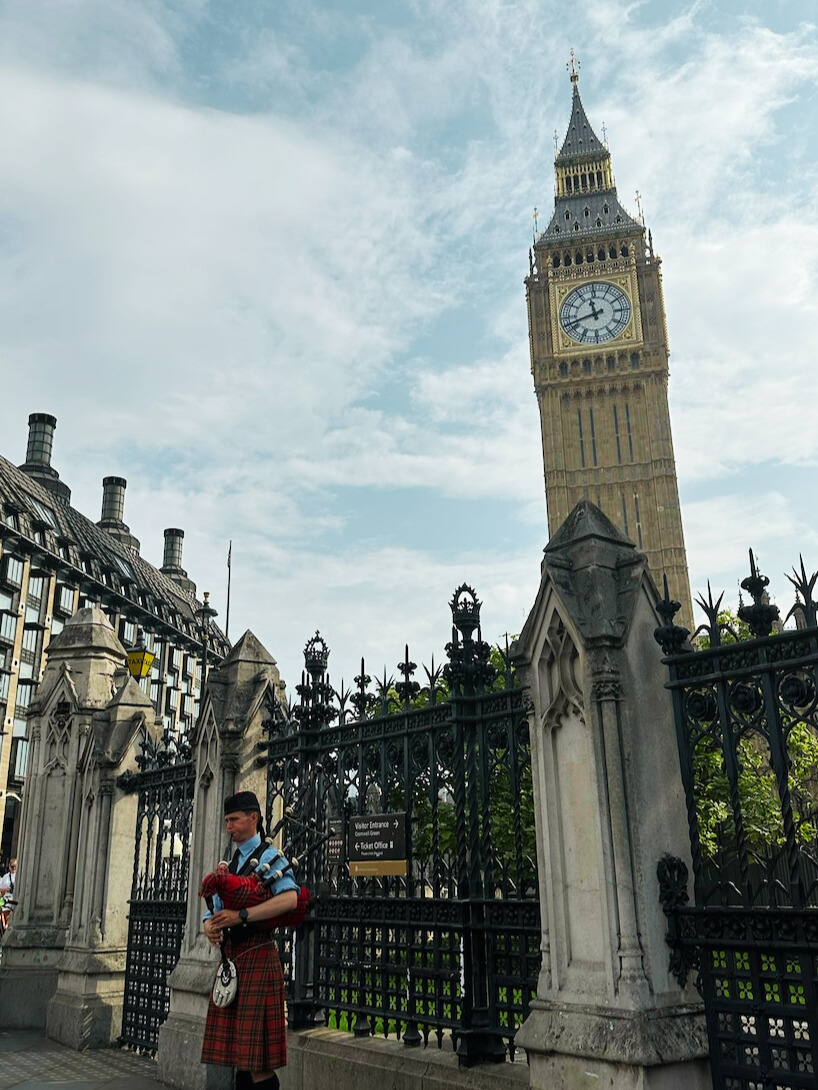 view of Big Ben Clock Tower and someone playing the bag pipes