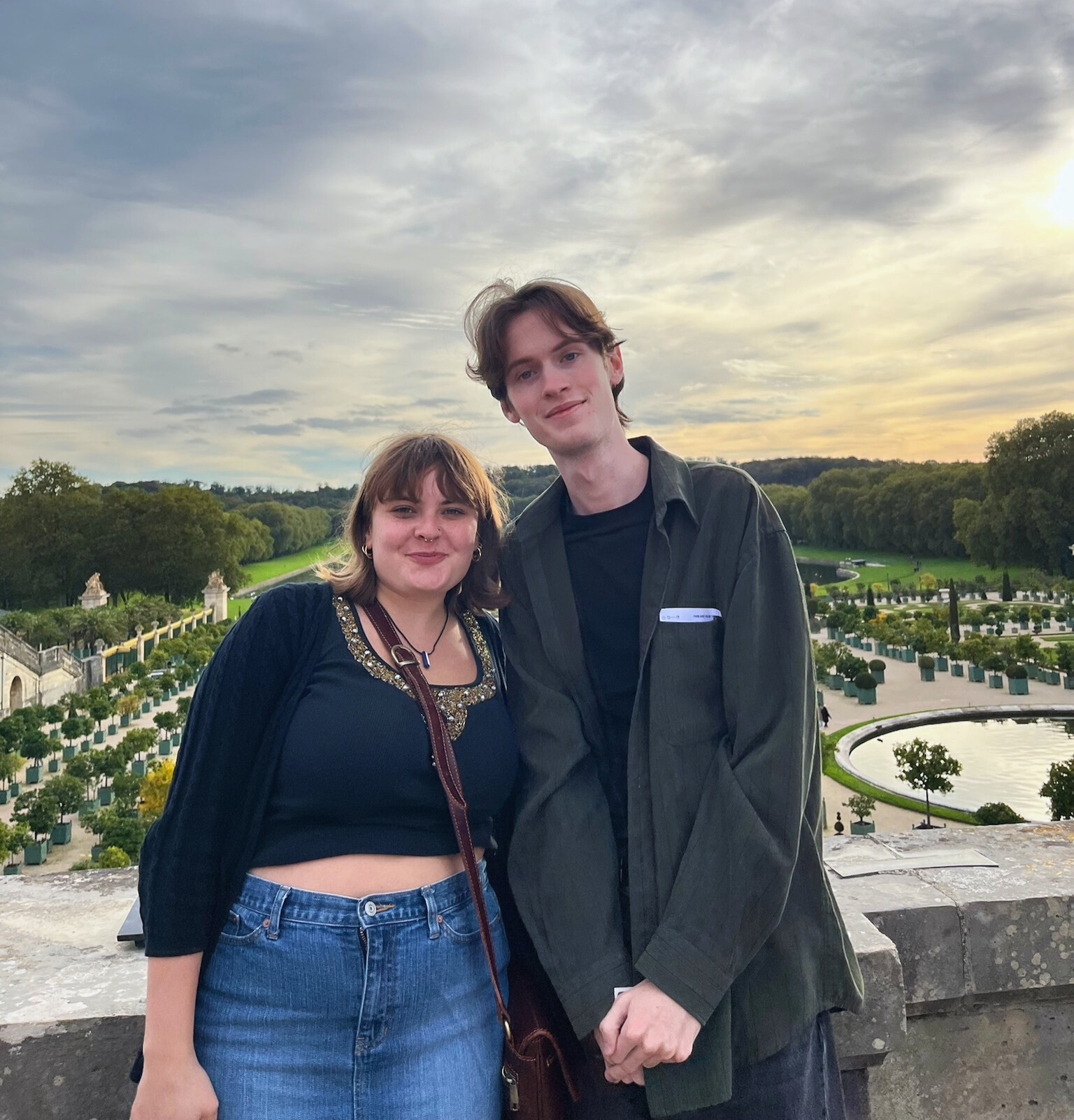 student and friend posing during sunset at a garden in France