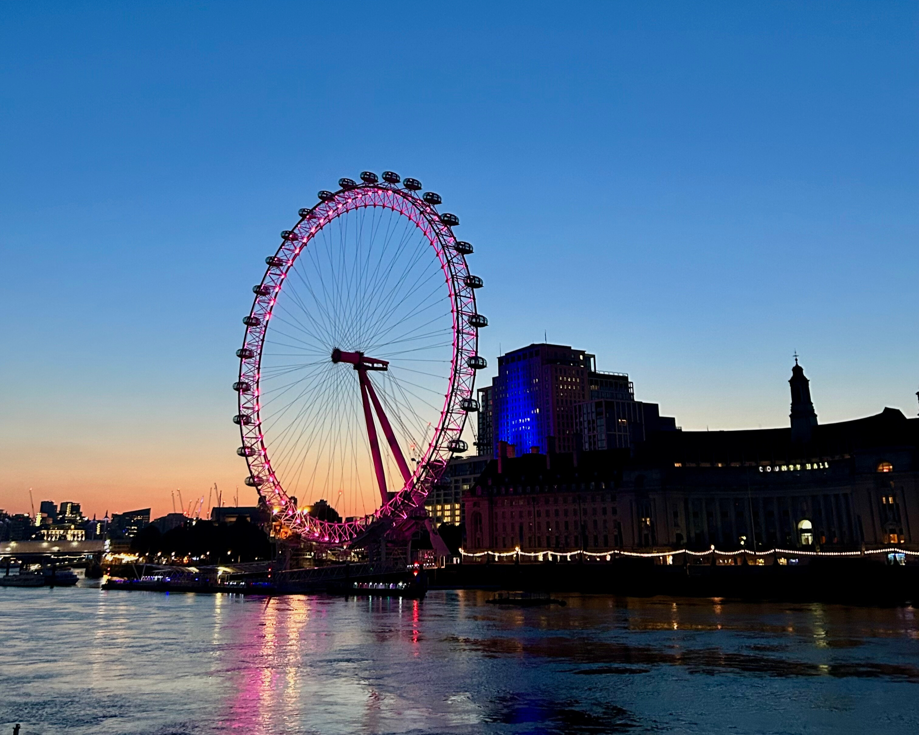 view of The London Eye on the south bank of the Thames River during Sunset