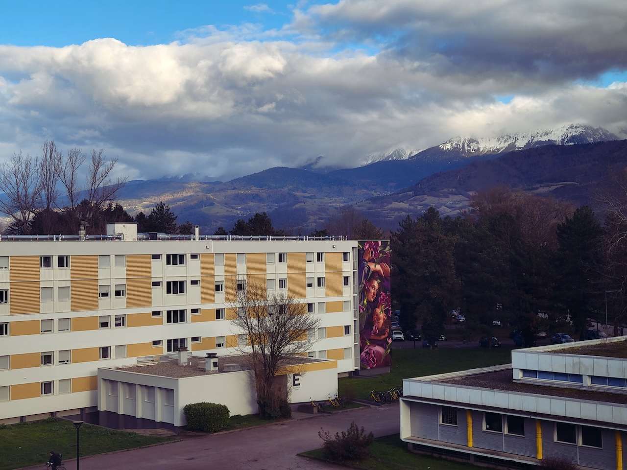 view of white and yellow building with mountains on the background