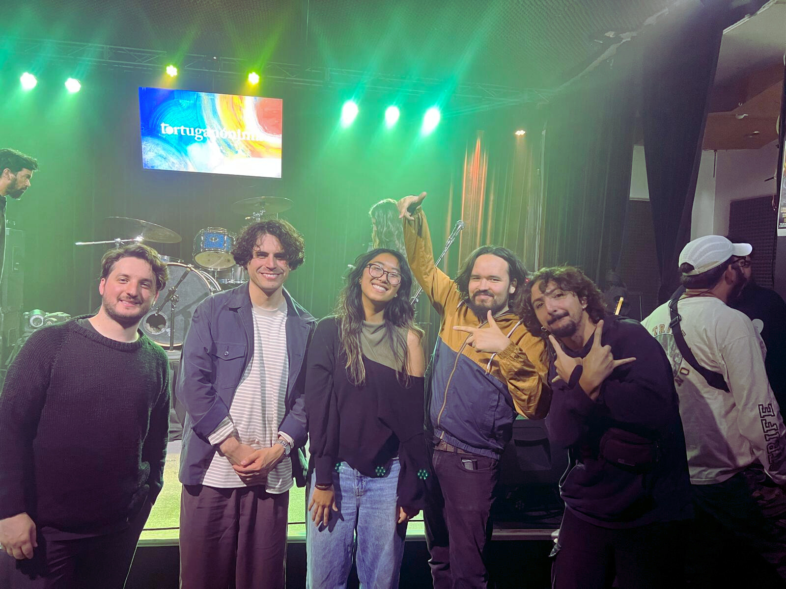 student visiting a music show in chile posing with band members