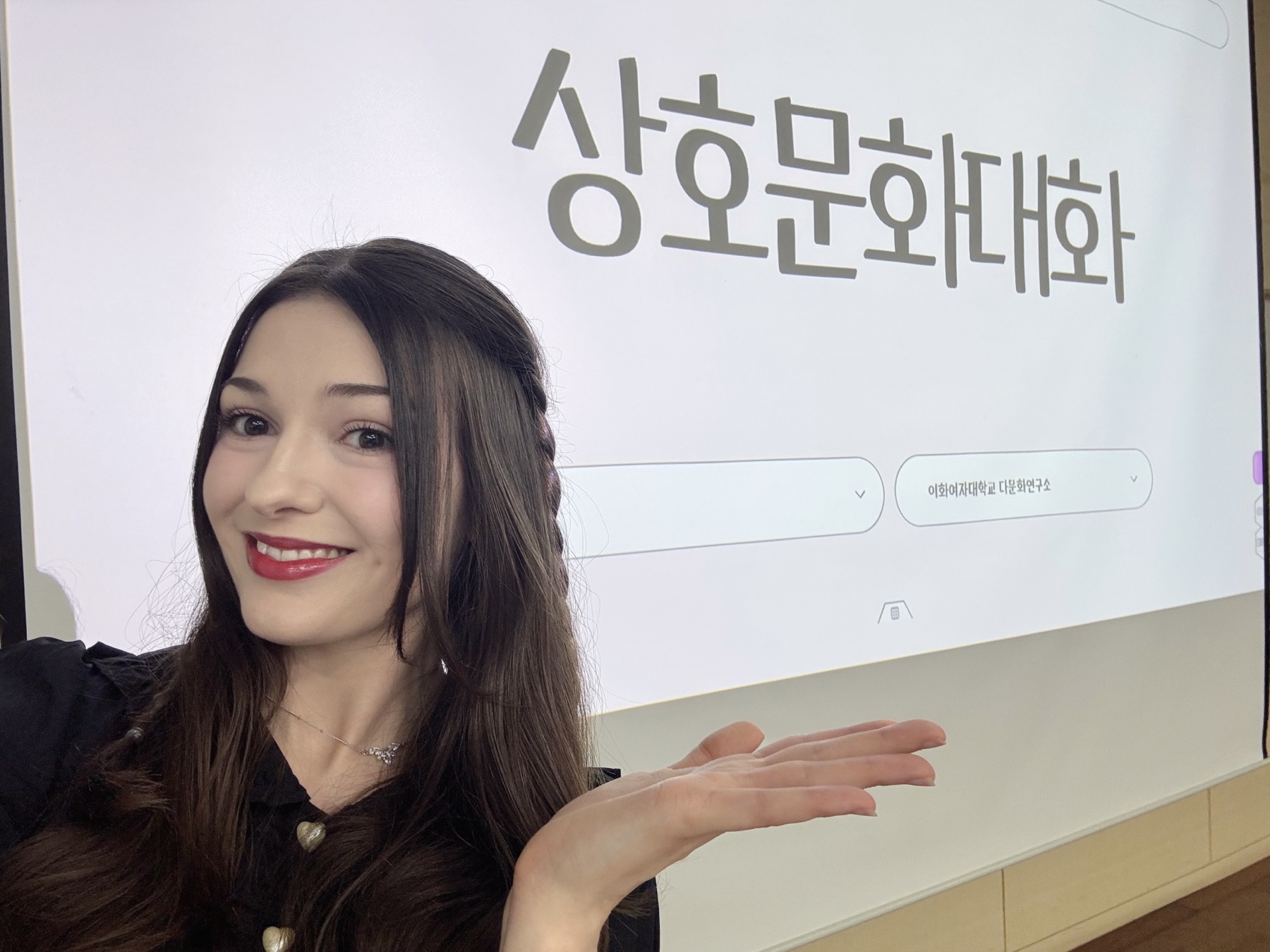 student, Julia Foland, posing in front of her PPT Presentation at EWHA