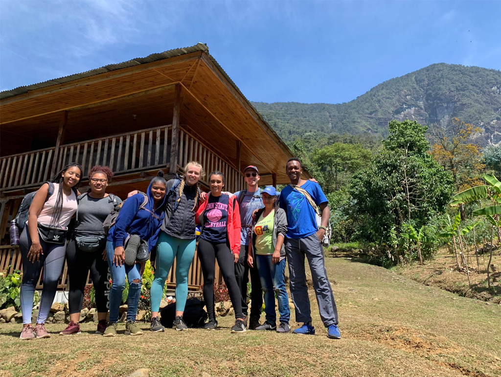 GW student Audrey Friedline poses with other students in front of a wooden house in Colombia.
