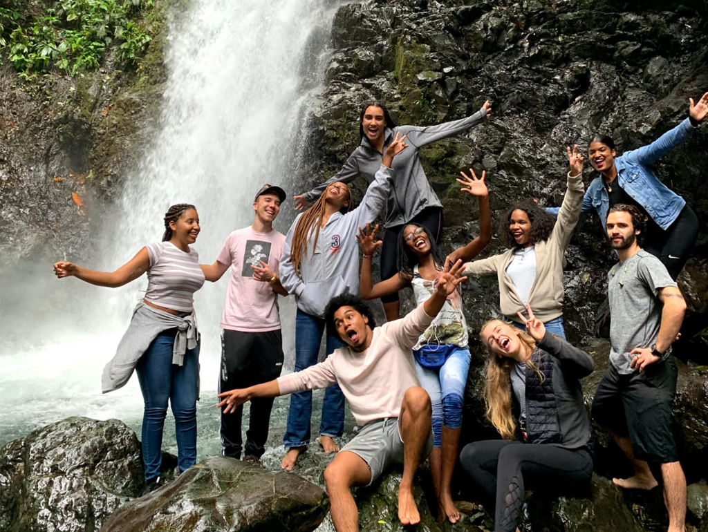 GW student Audrey Friedline poses with other students in front of a waterfall in Colombia.