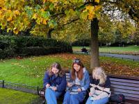 Lillian Buckley and two friends sitting on a park bench in London
