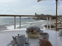 student enjoying a cup of coffee with view of the ocean