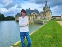 student standing in front of Chateau in Chantilly