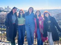 student with group of friends with view of the city behind them