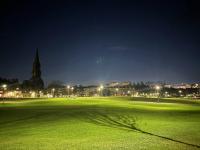 view of a student walking through the meadows near campus at night