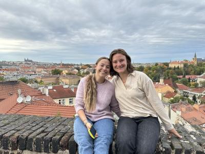 Madeline Lucy Pfeiffer and a friend sitting on a stone wall in France