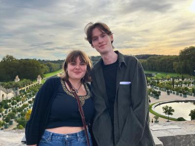 student and friend posing during sunset at a garden in France