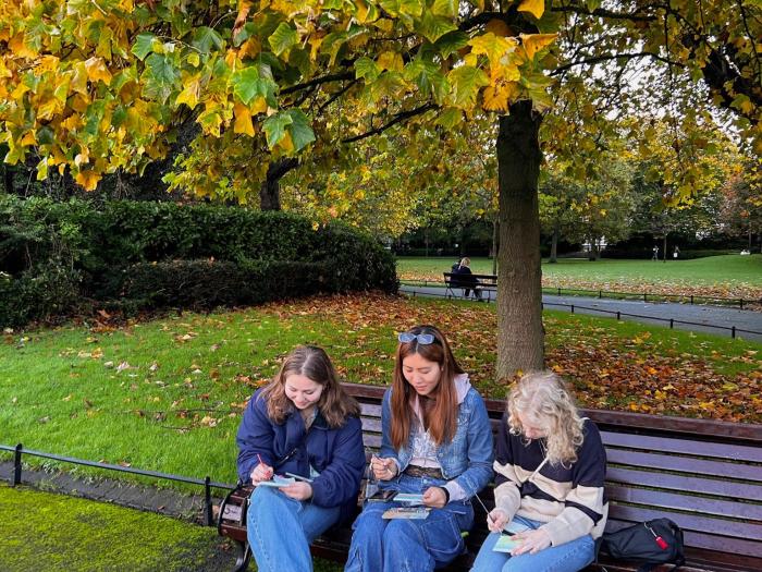 Lillian Buckley and two friends sitting on a park bench in London