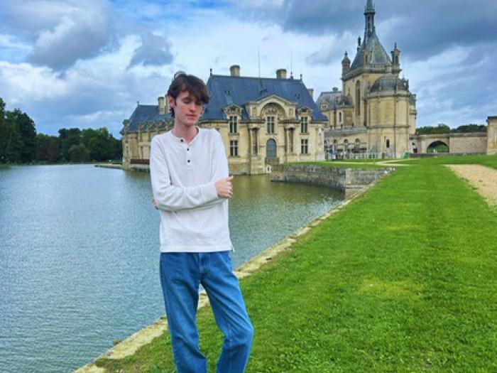 student standing in front of Chateau in Chantilly