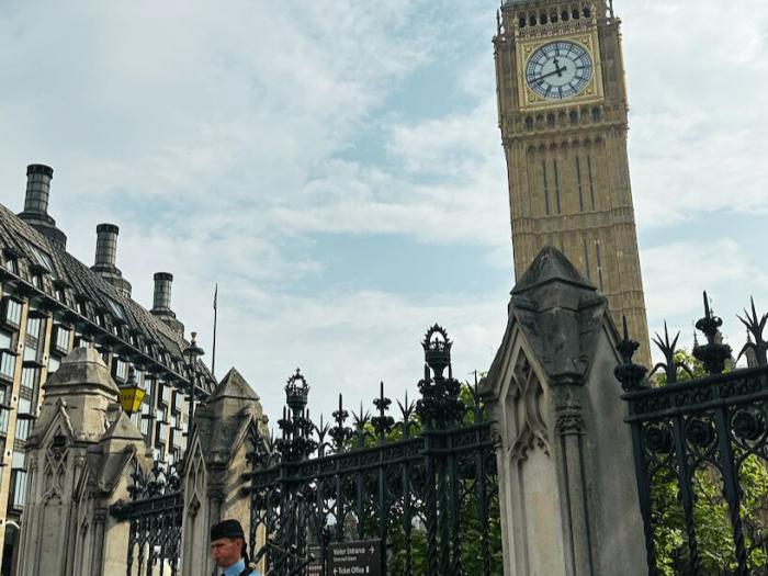 view of Big Ben Clock Tower and someone playing the bag pipes