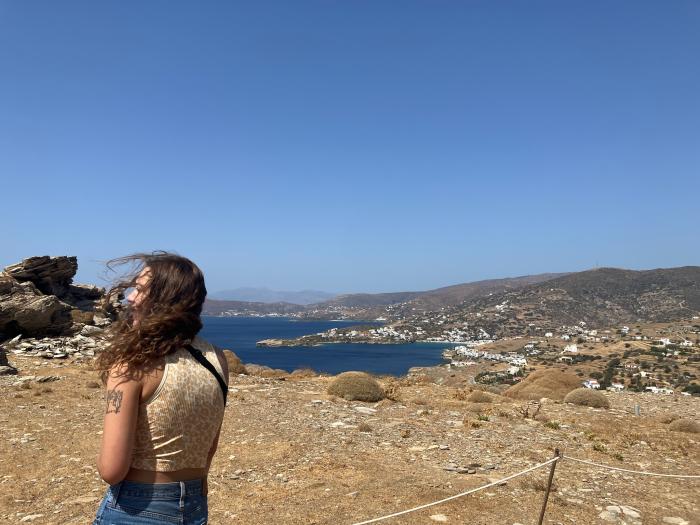 student overlooking a coastal cliff in the Mediterranean region