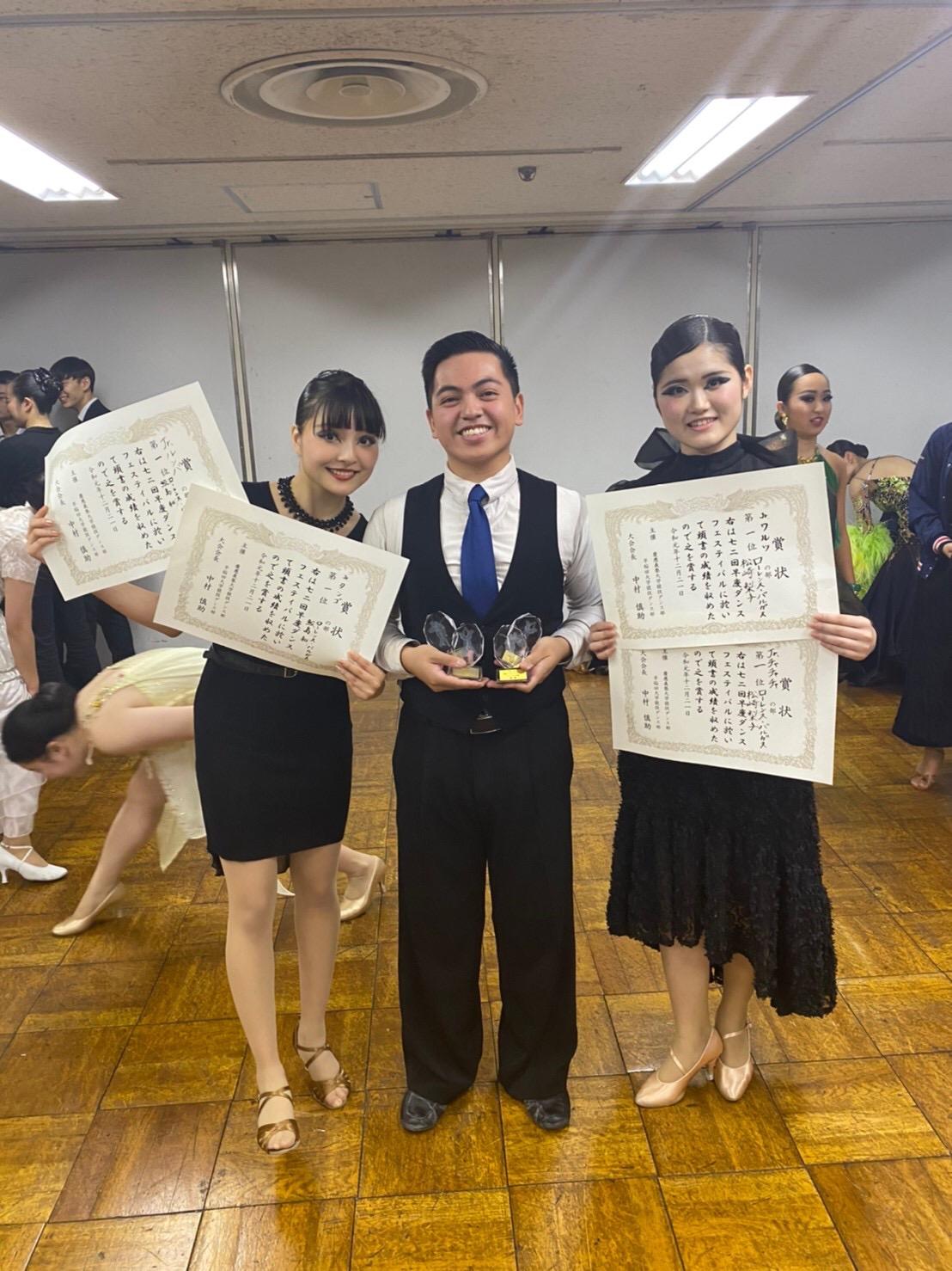 Lorenz Vargas holding awards given to the dance team.