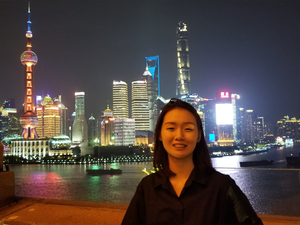A Global Bachelor's student poses for a nighttime photograph at the waterfront in Shanghai.