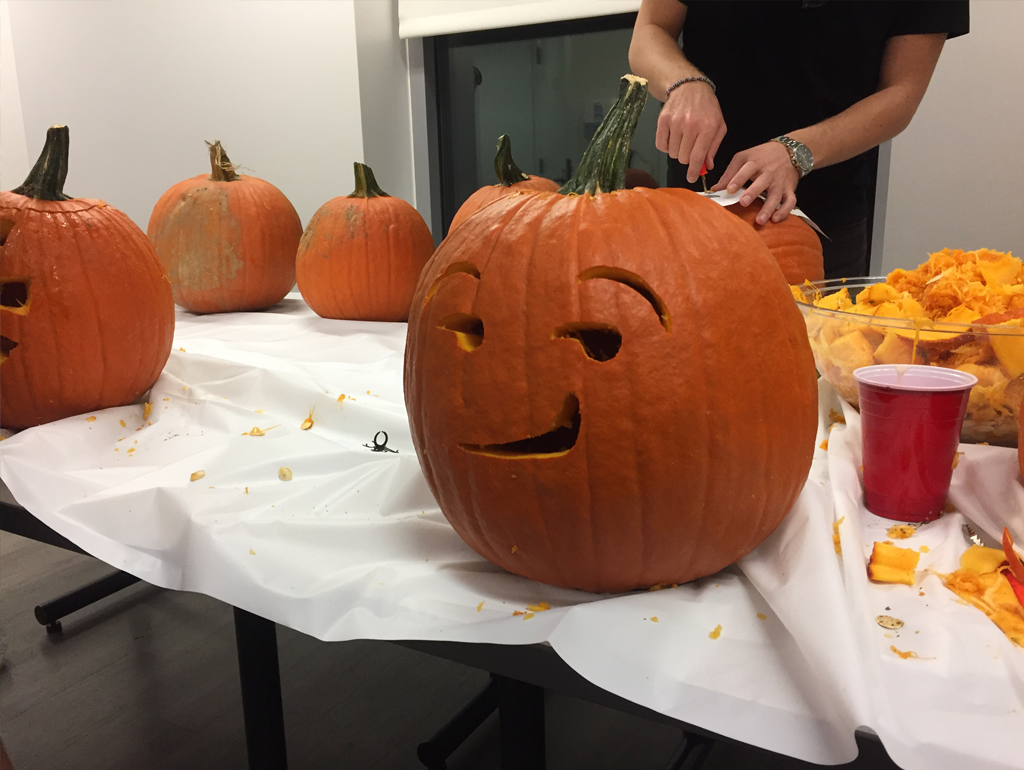 An exchange student carves a pumpkin into a Jack-o-Lantern during an event.