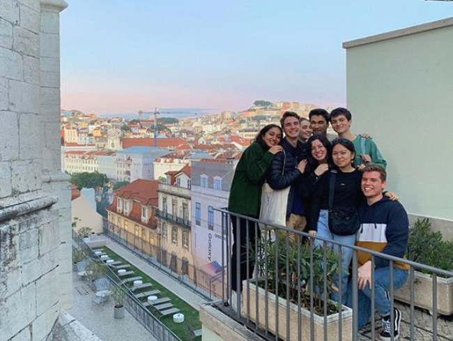 GW study abroad students pose in front of a sunlit cityscape.