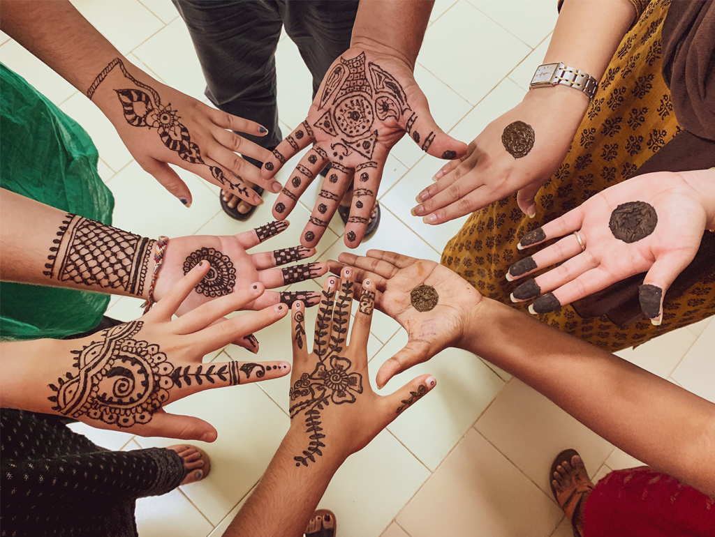 Students with henna artwork on their hands.